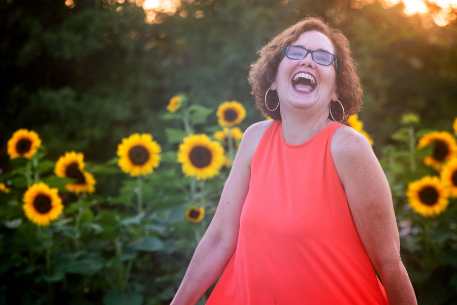 Aimee Bucher laughing in a sunflower field